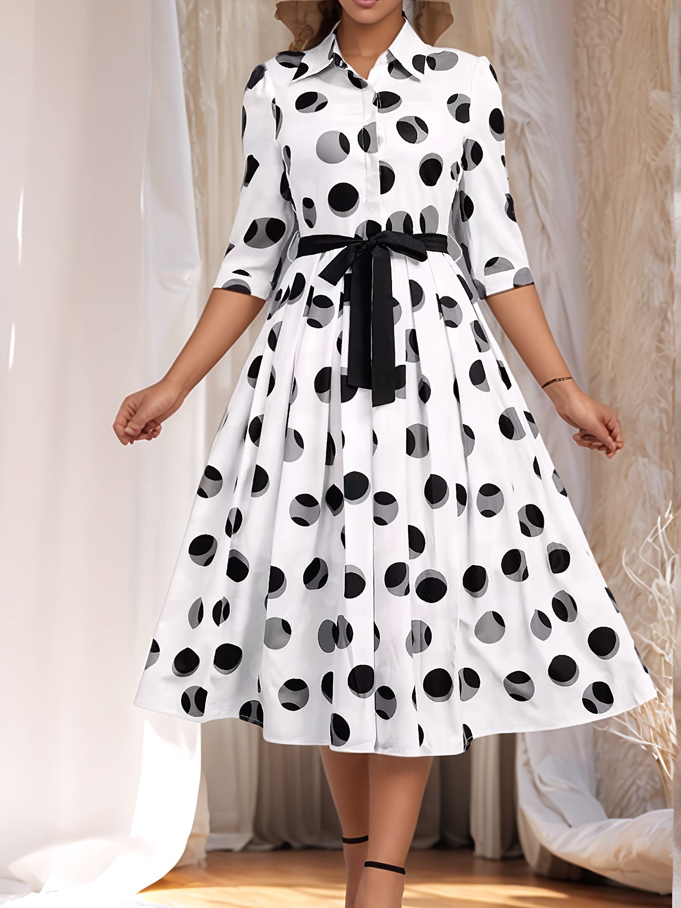 Vintage-inspired midi shirt dress with belt, polka dot print, collared design, and flared skirt in machine washable polyester.