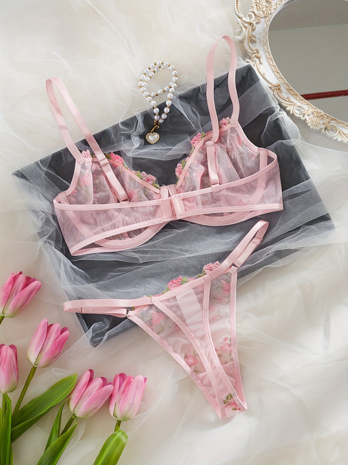 Chic French-inspired lingerie set in pink with floral embroidery and butterfly lace, featuring a sheer mesh bra and thong combo, medium support, hand wash only.