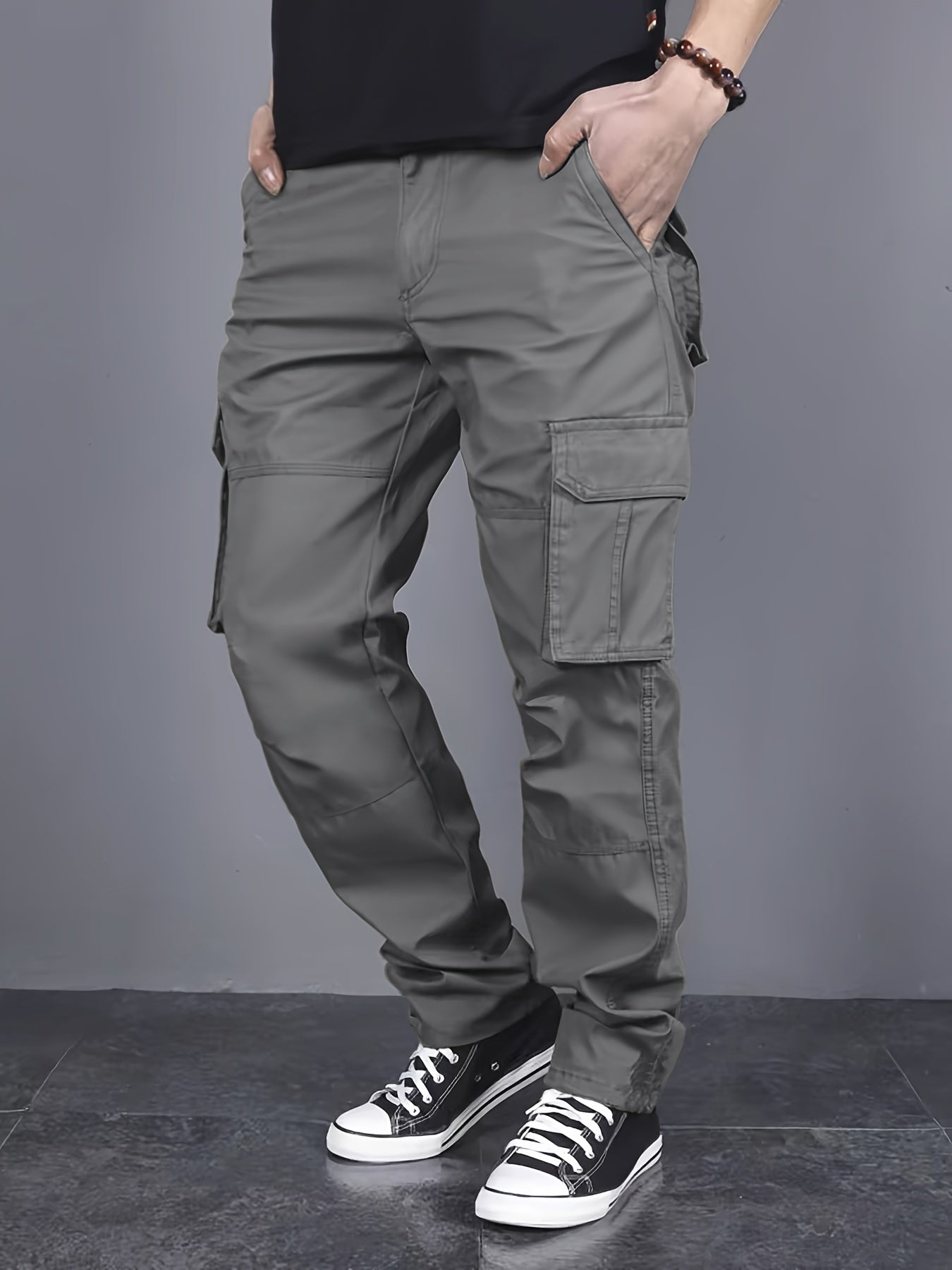 Solid color cargo pants with multiple flap pockets and a drawstring waistband, perfect for outdoor activities like hiking, fishing, and camping.