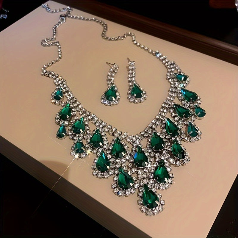 Elegantly designed in a vintage teardrop tassel style, this set features a luxurious green rhinestone necklace and matching earrings. Crafted with a copper base and plated in 18K gold, the earrings have 925 silver ear posts for a touch of sophistication.