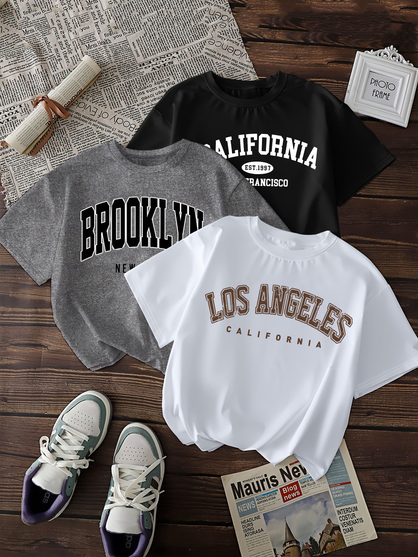 Three casual geometric-patterned t-shirts for women, polyester crew neck short sleeve tees with regular length knit fabric, featuring prints of Brooklyn, Los Angeles, and California.