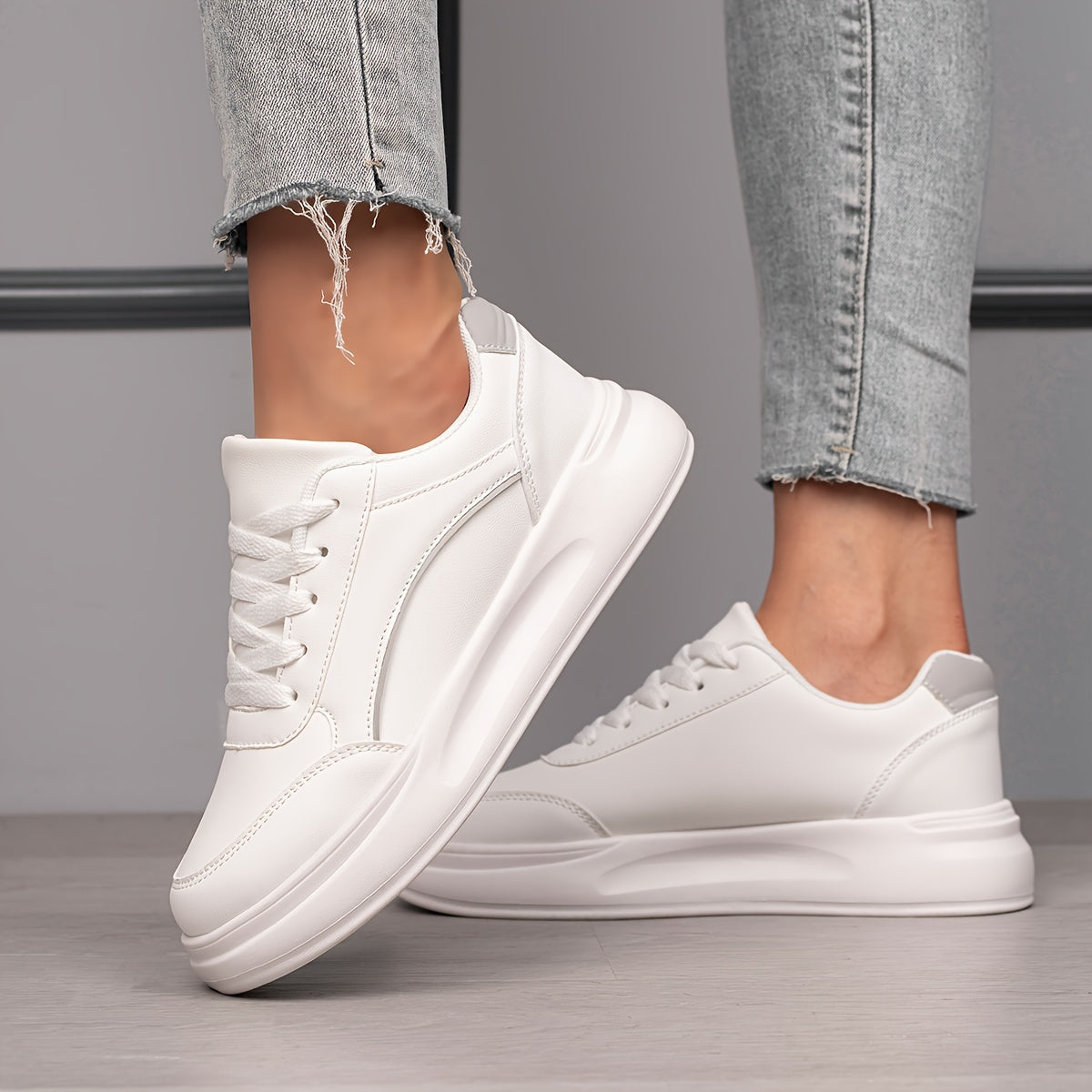 Women's white skate shoes with round toe, lace up closure, and low top flat design. Comfortable for casual wear and sports.