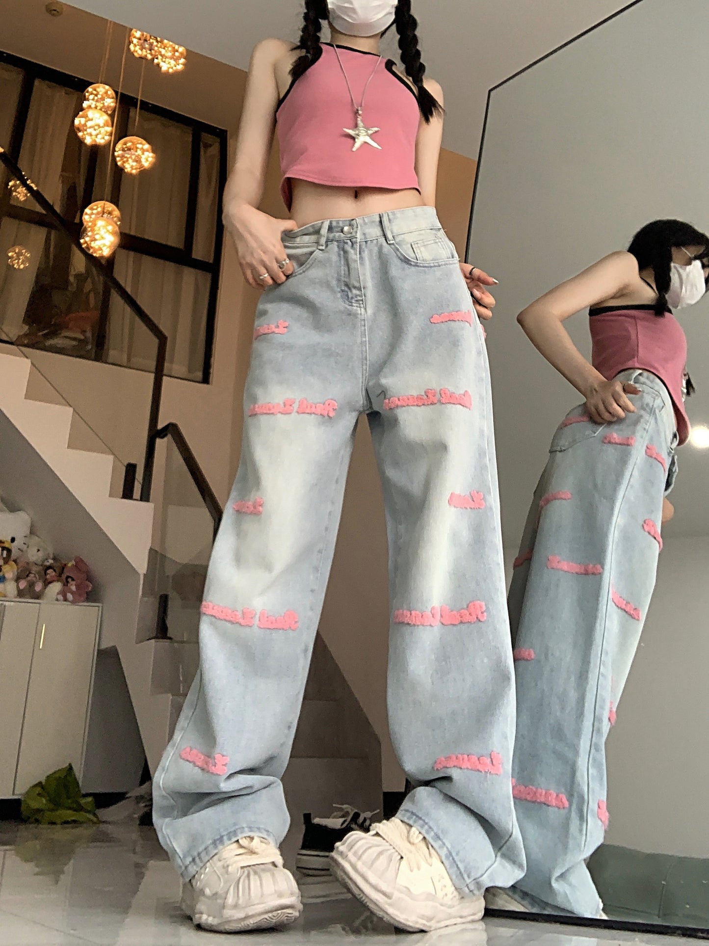 High-waisted embroidered denim jeans with straight-leg, button fly closure, and slight stretch.