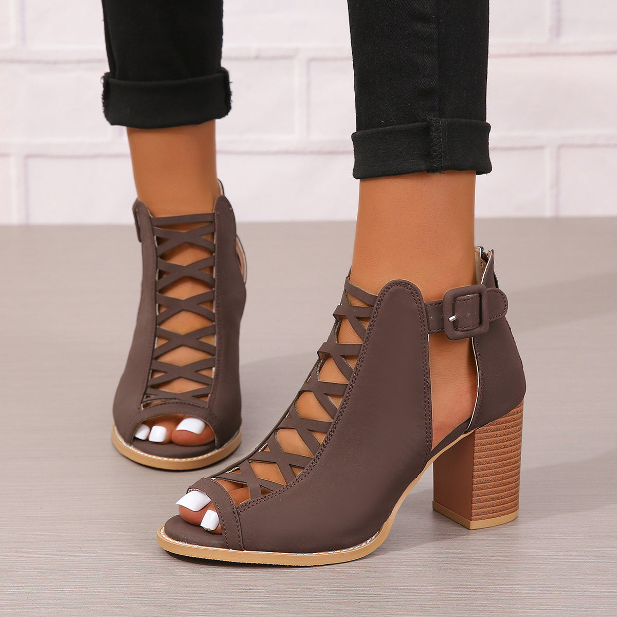 Women's brown faux leather ankle boots with elegant design including peep toe, chunky heel, crisscross straps, and buckle closure. Comfortable summer pumps with rubber sole.