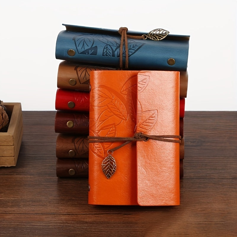 Vintage spiral-bound faux leather notebook with leaf-embossed design and strap closure, available in black, orange, and blue, perfect for students and travelers.