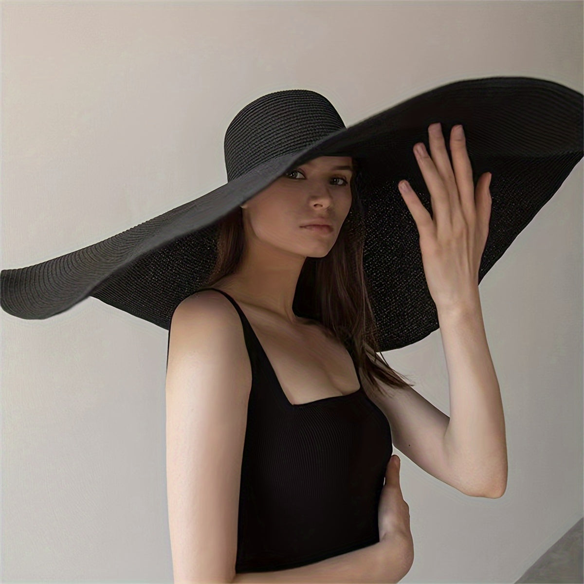 Foldable straw sun hat with extra wide brim and UV protection, perfect for beach vacations, travel, and photography. Black textured design.