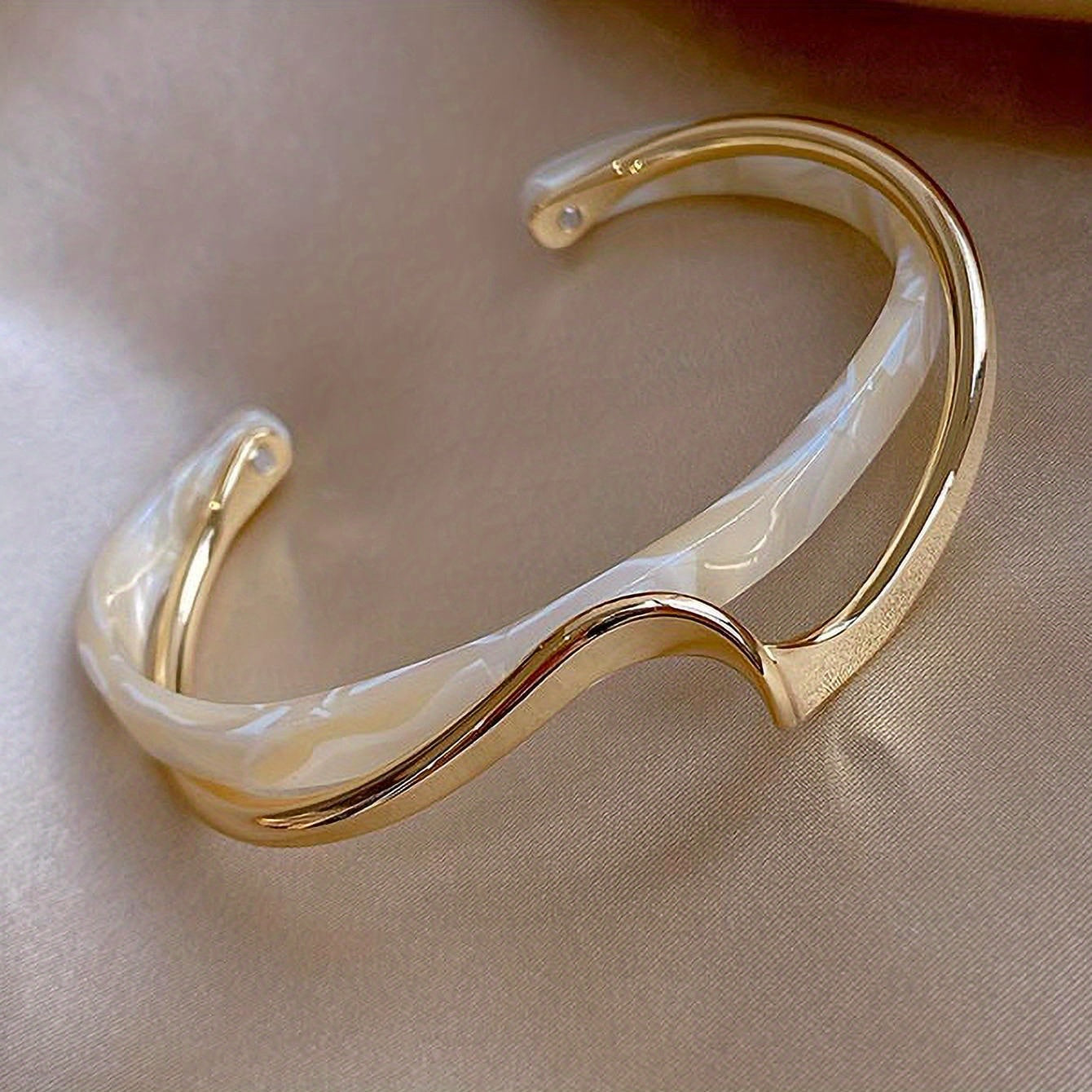 Wave-shaped cuff bangle with faux pearl inlay, featuring a minimalist style in 18K gold plating, ideal for women's jewelry collection